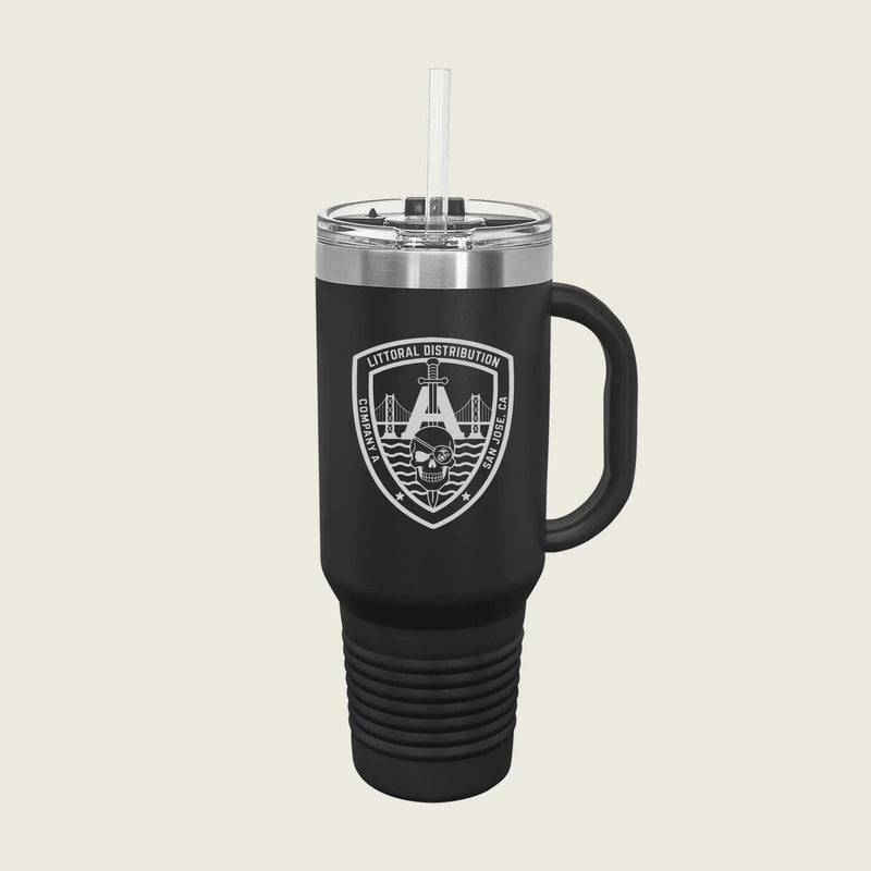 A matte black insulated travel tumbler with a clear lid and straw, featuring a white shield logo on the front with a skull and bridge graphic, set against a solid light beige background.