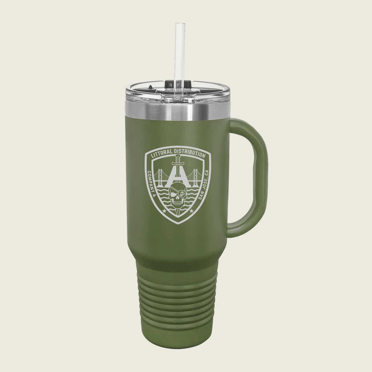 An olive green insulated travel tumbler with a handle, clear lid, and straw, featuring a white printed military-style crest on the front, shown on a light beige background.