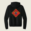 Black hoodie with a red and yellow emblem on the back against a beige background