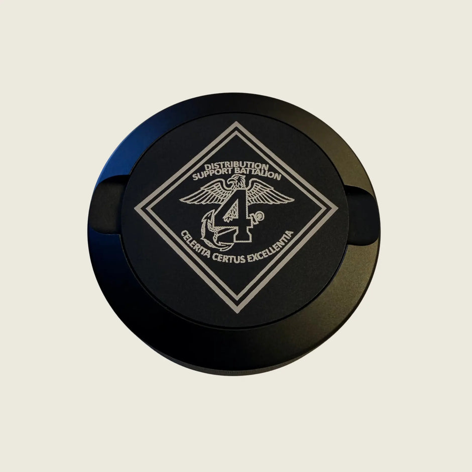 Round black object with a logo and text on a beige background