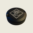 Black circular object with a logo on a beige background