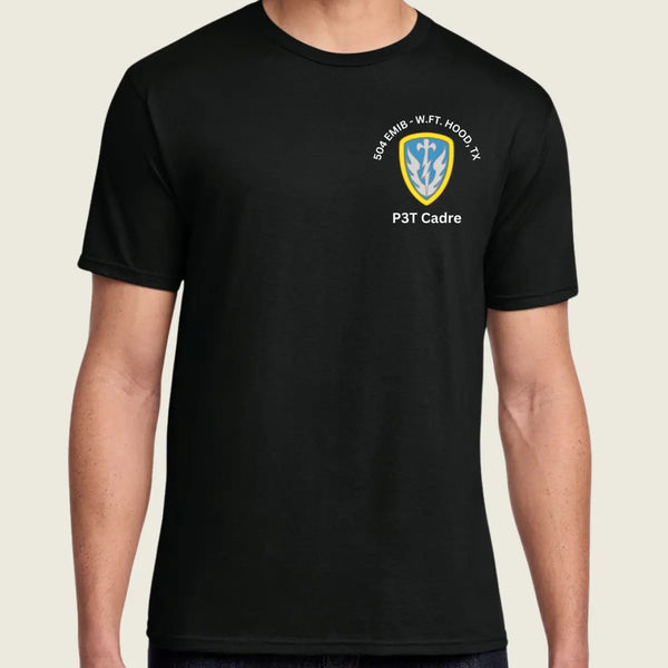 A man wearing a black short-sleeve t-shirt with a US Army crest printed on the left chest, set against a plain light beige background.