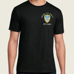 A man wearing a black short-sleeve t-shirt with a US Army crest printed on the left chest, set against a plain light beige background.