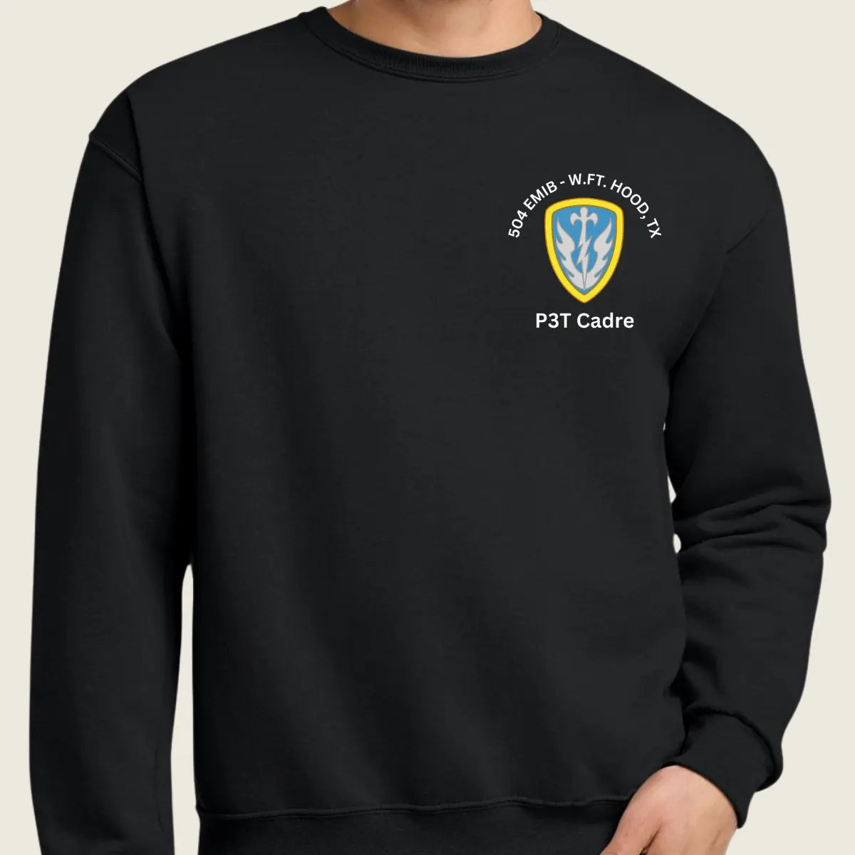 A person wearing a black crewneck sweatshirt with a small military logo and text on the left chest 