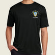 A man wearing a black short-sleeve crewneck t-shirt with a small military-style crest on the left chest. The crest features a yellow and blue shield with white text reading Cadre'.