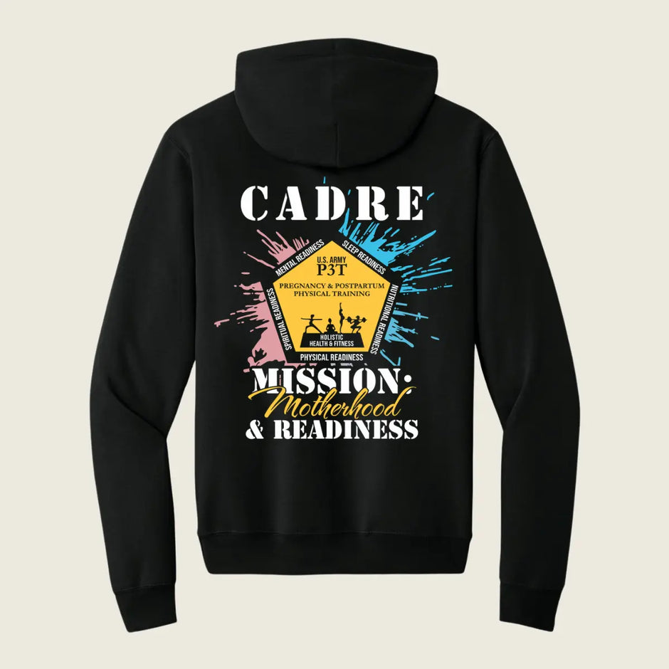 A black pullover hoodie shown from the back, featuring a colorful graphic print with the text 'CADRE' and 'MISSION: Motherhood & Readiness' around a central yellow badge design, on a light beige background.