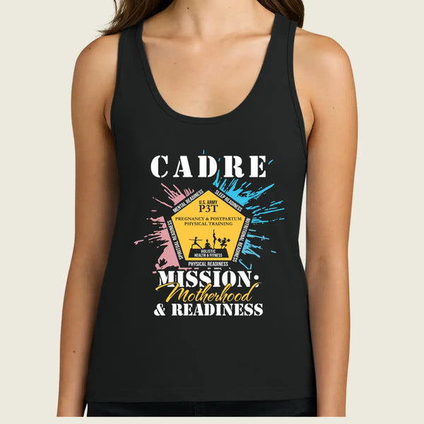 A woman wearing a black racerback tank top with a colorful graphic print on the front. The graphic features the text 'CADRE MISSION, Motherhood & READINESS' with a central yellow badge illustration and blue, pink, and white paint splatter details.