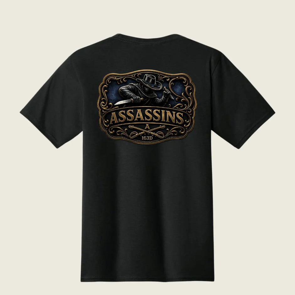 A black short-sleeve t-shirt shown from the back, featuring a large graphic print of a raven holding a knife inside an ornate frame, with the word 'ASSASSINS' and '163D' printed below in gold and brown tones.