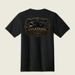 A black short-sleeve t-shirt shown from the back, featuring a large graphic print of a raven holding a knife inside an ornate frame, with the word 'ASSASSINS' and '163D' printed below in gold and brown tones.