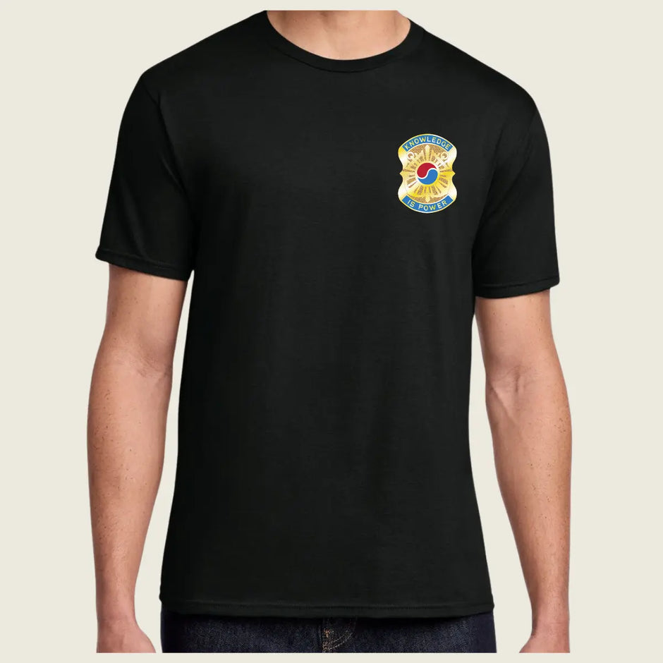 Black t-shirt with a colorful logo on the chest against a beige background