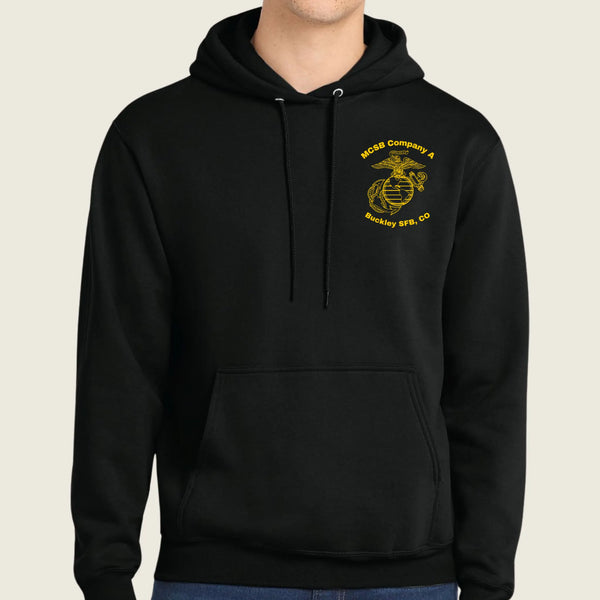 A black pullover hoodie with a yellow embroidered US Marine Corps Eagle, Globe, and Anchor emblem on the left chest, worn by a model against a light beige background.