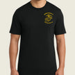 A man wearing a black short-sleeve crewneck t-shirt with a yellow embroidered USMC (United States Marine Corps) Eagle, Globe, and Anchor insignia on the left chest, set against a solid light beige background.