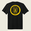 A black short-sleeve t-shirt shown from the back, featuring a large yellow circular graphic print on the upper back with an eagle, globe, and anchor emblem, and the text 'Marine Cryptologic Support Battalion' and 'Company A'.