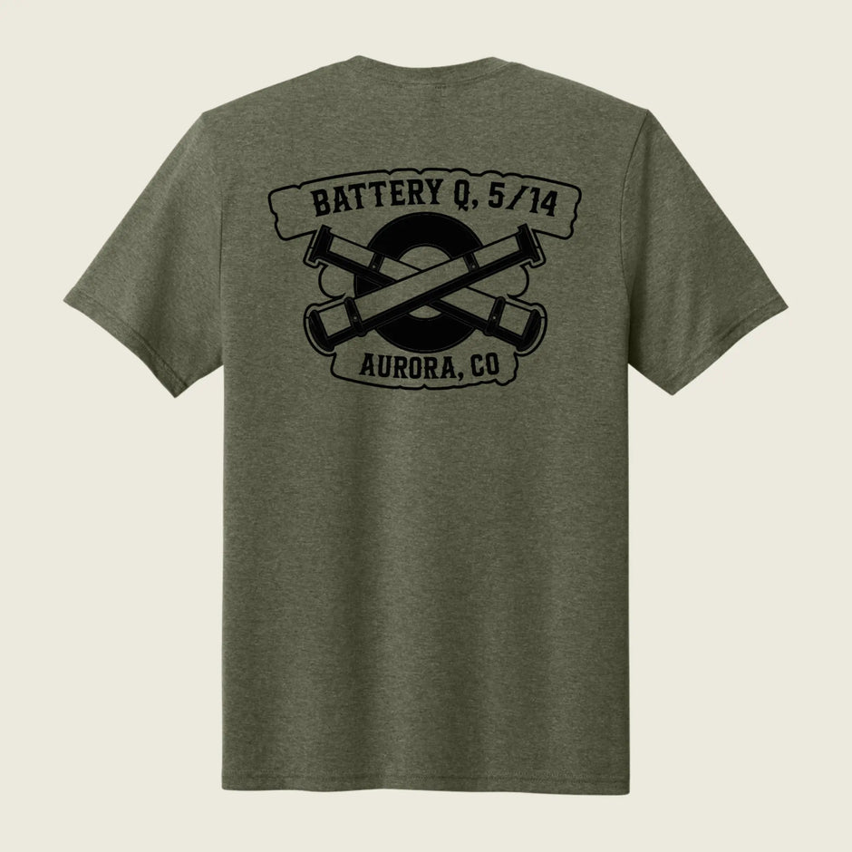 An olive green heather short-sleeve t-shirt shown from the back, featuring a black graphic print of crossed artillery shells with the text 'BATTERY Q, 5/14' and 'AURORA, CO'.