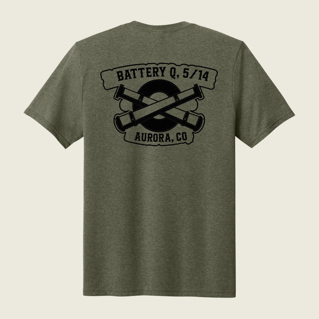 An olive green heather short-sleeve t-shirt shown from the back, featuring a black graphic print of crossed artillery shells with the text 'BATTERY Q, 5/14' and 'AURORA, CO'.