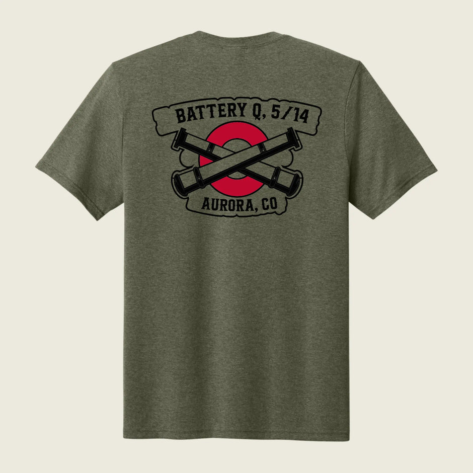 A heather olive green short-sleeve t-shirt shown from the back, featuring a graphic print of crossed black cannons over a red circle with banners reading 'BATTERY Q, 5/14' and 'AURORA, CO'.