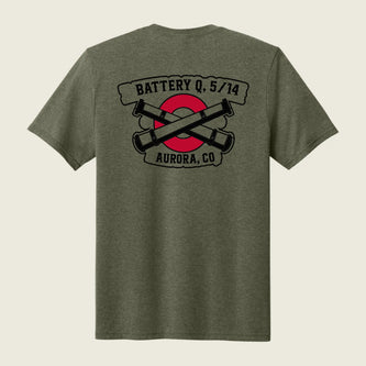 A heather olive green short-sleeve t-shirt shown from the back, featuring a graphic print of crossed black cannons over a red circle with banners reading 'BATTERY Q, 5/14' and 'AURORA, CO'.