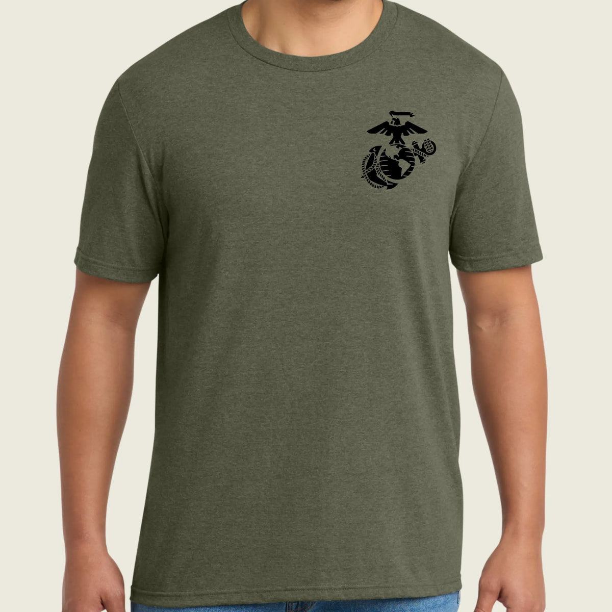 Person wearing a green t-shirt with a black logo on the chest against a beige background