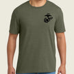 Person wearing a green t-shirt with a black logo on the chest against a beige background