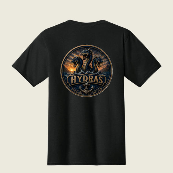 A black short-sleeve t-shirt shown from the back, featuring a large circular graphic print of three sea serpents rising from water at sunset with the word 'HYDRAS' and the phrase 'Strength Multiplied' below.