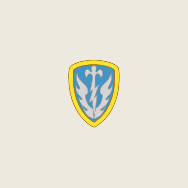 A shield-shaped emblem with a yellow border, light blue center, and a white stylized bird or flame motif, centered on a plain light beige background.