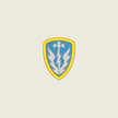 A shield-shaped emblem with a yellow border, light blue center, and a white stylized bird or flame motif, centered on a plain light beige background.