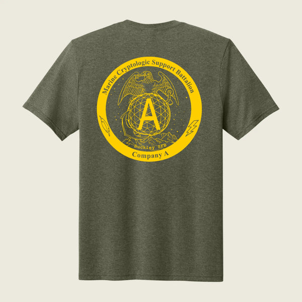 A heather olive green t-shirt shown from the back, featuring a large yellow circular graphic print with the USMC Eagle, Globe, and Anchor emblem and the text 'Marine Cryptologic Support Battalion Company A'.