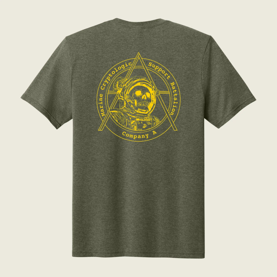 An olive green heather short-sleeve t-shirt shown from the back, featuring a large yellow graphic print of a skull in an astronaut helmet inside a triangle emblem with the text 'Hastening Cryptologic Support Mission Company A'.