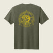 An olive green heather short-sleeve t-shirt shown from the back, featuring a large yellow graphic print of a skull in an astronaut helmet inside a triangle emblem with the text 'Hastening Cryptologic Support Mission Company A'.