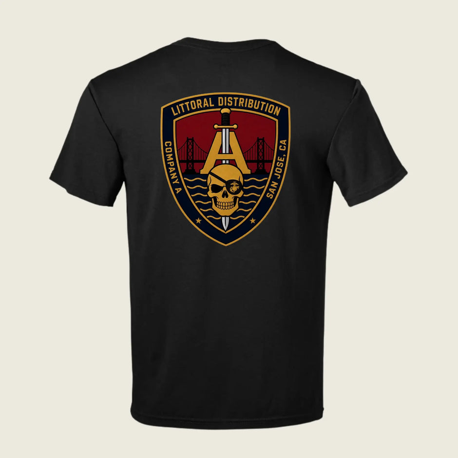 A black short-sleeve t-shirt shown from the back, featuring a large military-style graphic emblem on the upper back. The emblem is shield-shaped with a gold border, a gold anchor, a skull, and a red background, with text reading 'LITTORAL DISTRIBUTION' 