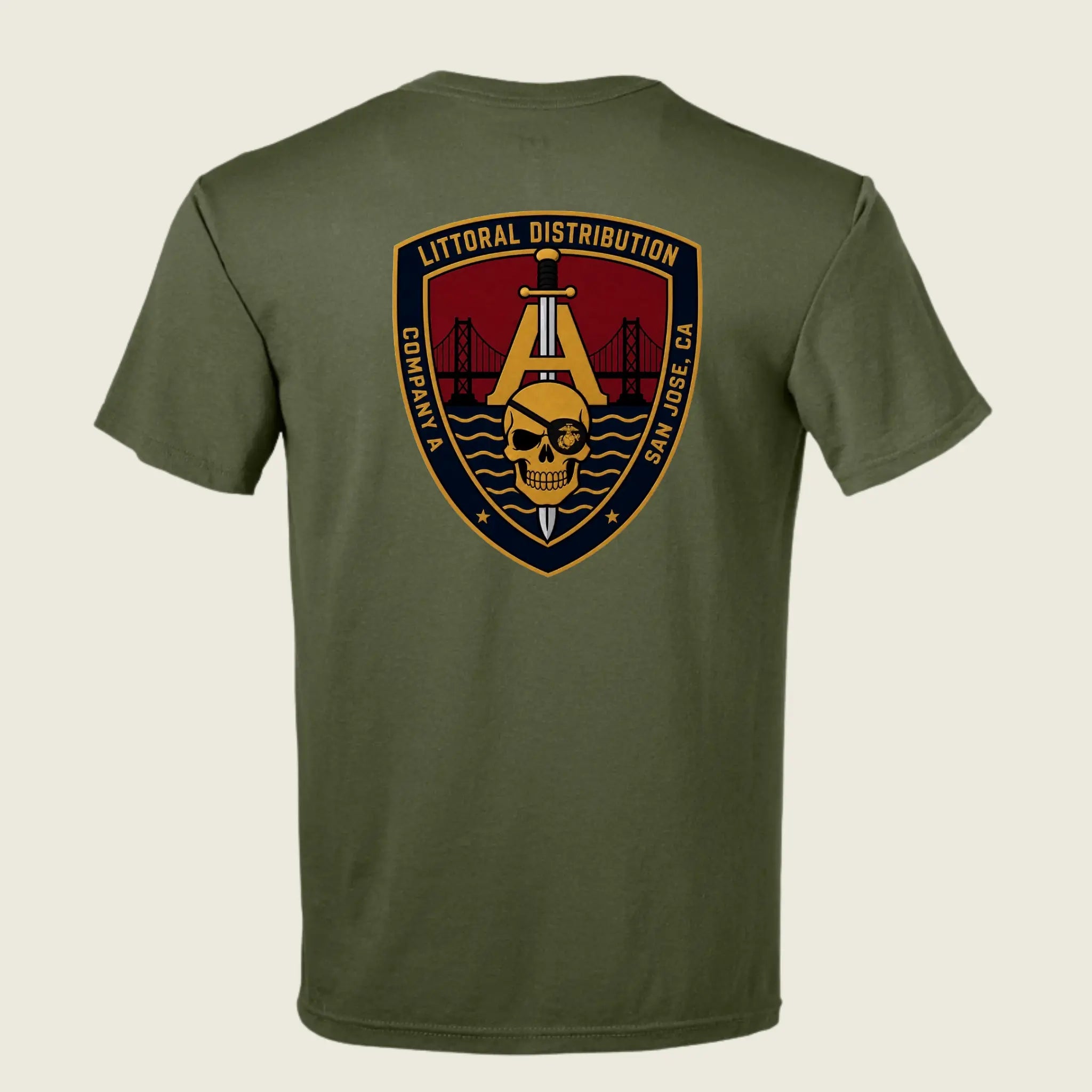 An olive green short-sleeve t-shirt shown from the back, featuring a large military-style shield patch graphic on the upper back with a skull, bridge, and text reading 'LITTORAL DISTRIBUTION' and 'COMPACT SAN JOSE CA'.