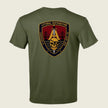 An olive green short-sleeve t-shirt shown from the back, featuring a large military-style shield patch graphic on the upper back with a skull, bridge, and text reading 'LITTORAL DISTRIBUTION' and 'COMPACT SAN JOSE CA'.