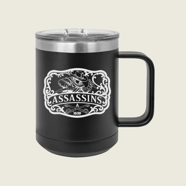 A black insulated travel mug with a clear lid and black handle, featuring a white 'Assassins' graphic on the front, set against a solid light beige background.