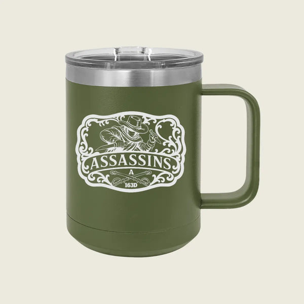 An olive green insulated travel mug with a stainless steel lid and a white 'Assassins' graphic on the front, set against a solid light beige background.