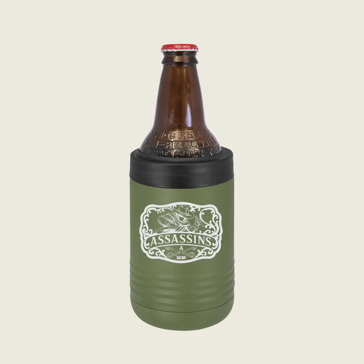 An olive green insulated bottle sleeve with a black top band holding a brown glass bottle, shown on a light beige background. The sleeve features a white graphic with the word 'ASSASSINS'