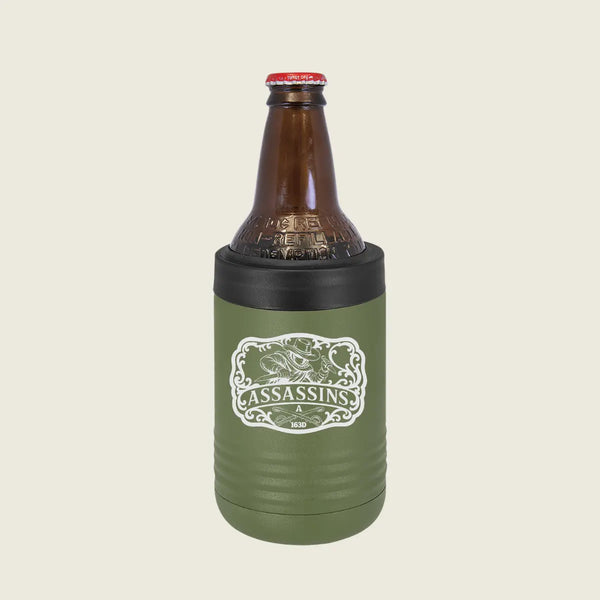 An olive green insulated bottle sleeve with a black top band holding a brown glass bottle, shown on a light beige background. The sleeve features a white graphic with the word 'ASSASSINS'