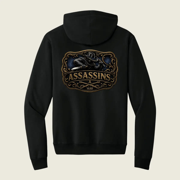 A black pullover hoodie shown from the back, featuring a large graphic print with the word 'ASSASSINS' in gold and a dark illustration above it, set against a light beige background.