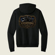 A black pullover hoodie shown from the back, featuring a large graphic print with the word 'ASSASSINS' in gold and a dark illustration above it, set against a light beige background.