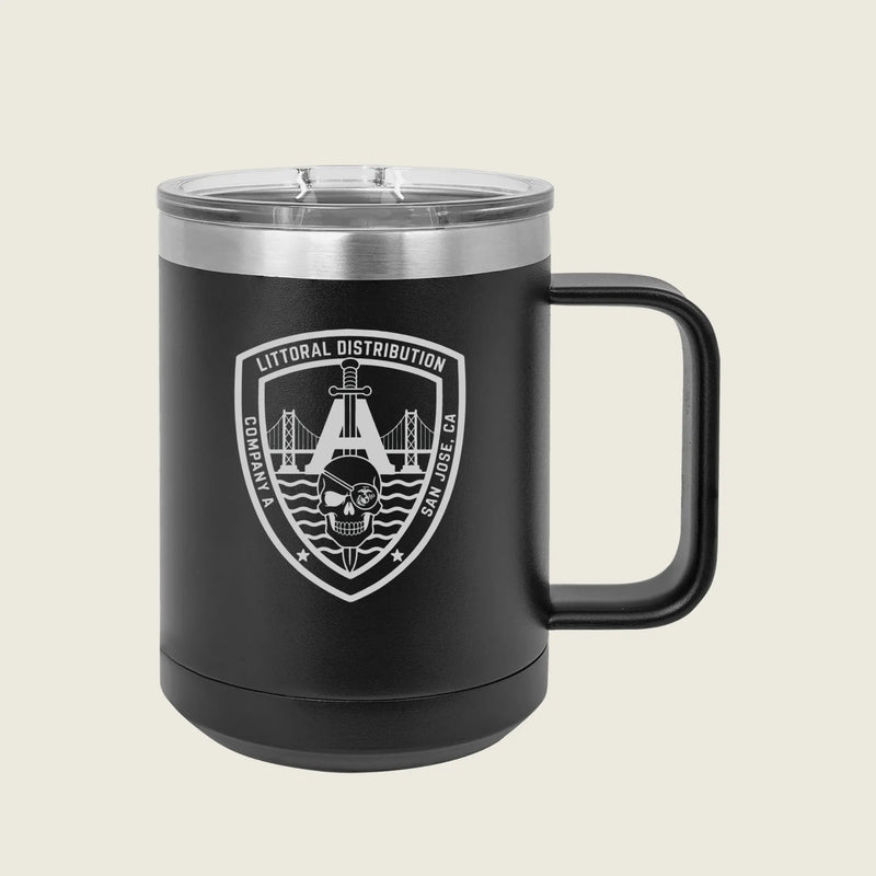 A matte black insulated travel mug with a clear plastic lid and a black handle, featuring a white printed shield logo on the front that reads 'LITTORAL DISTRIBUTION' with a bridge, skull, and wave design. The mug is photographed against a solid, light beige background.