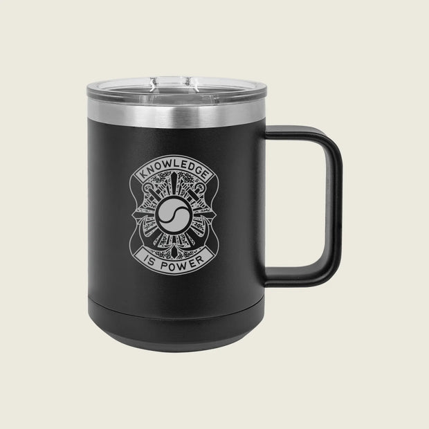 A matte black insulated travel mug with a clear lid and a black handle, featuring a white graphic design on the front that reads 'KNOWLEDGE IS POWER' around a circular emblem. The mug is photographed against a solid, light beige background.