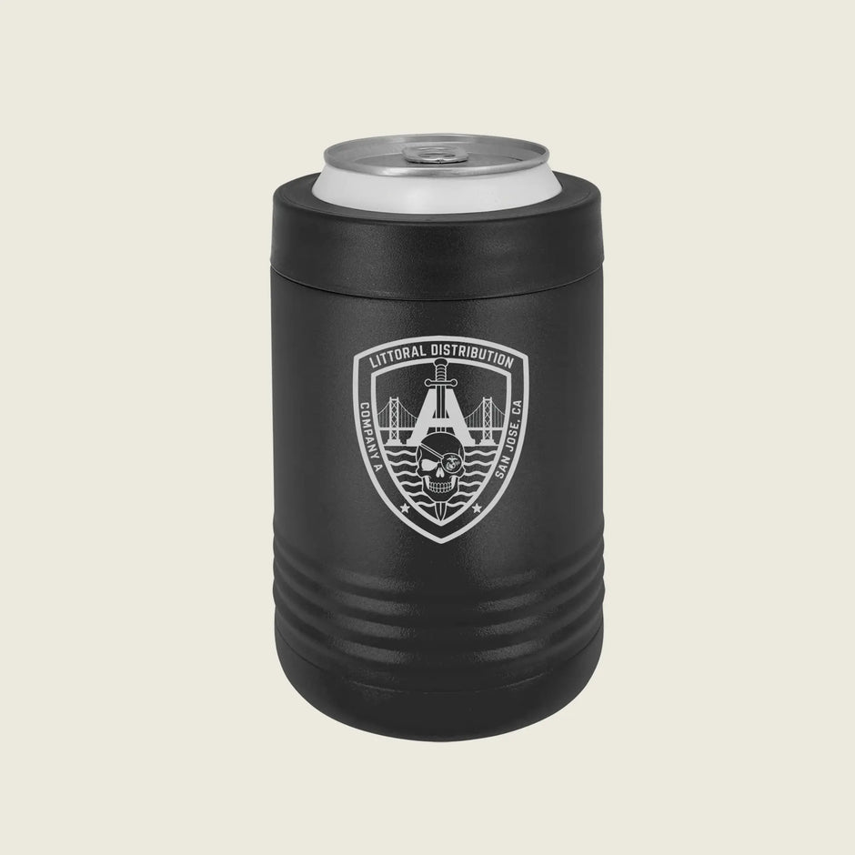 A matte black insulated can cooler sleeve holding a silver aluminum can, featuring a white shield emblem with a bridge, skull, on a light beige background.