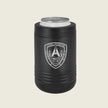 A matte black insulated can cooler sleeve holding a silver aluminum can, featuring a white shield emblem with a bridge, skull, on a light beige background.