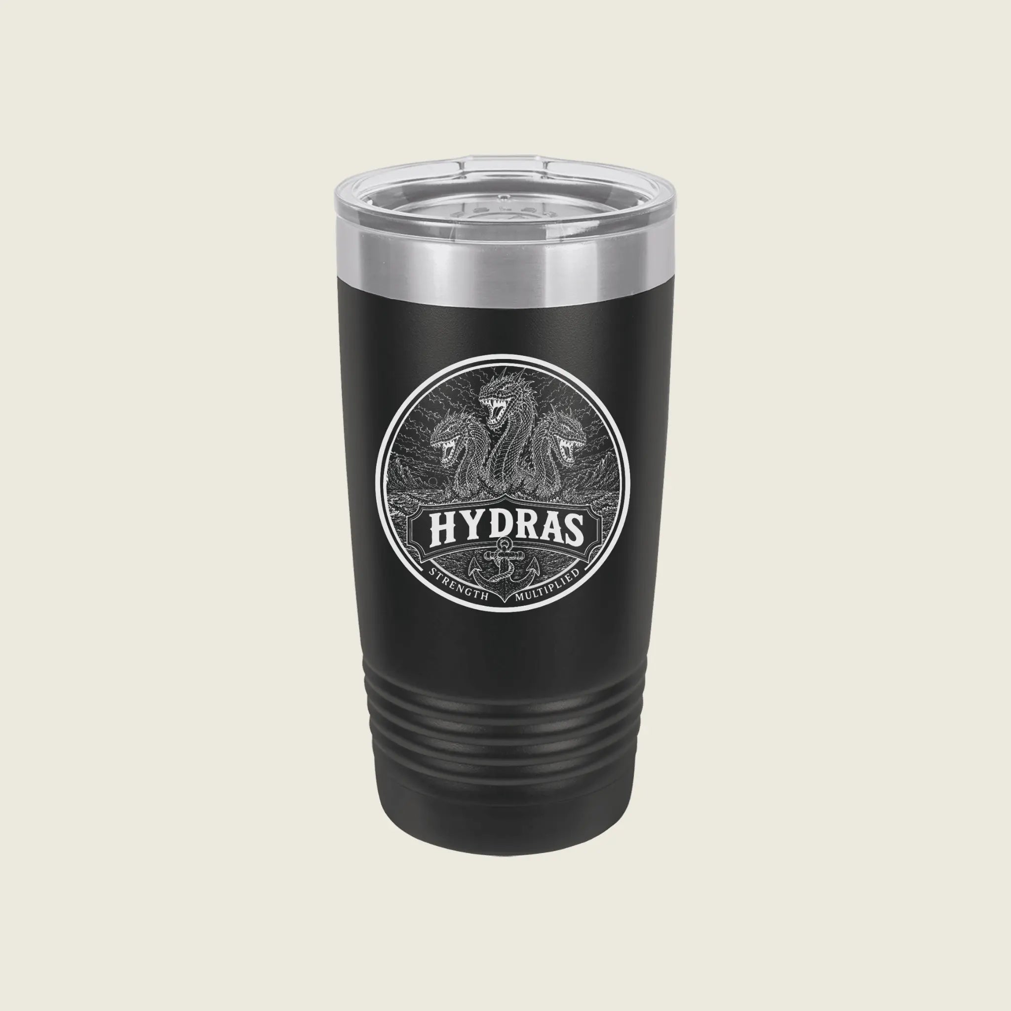 A black insulated travel tumbler with a clear lid, featuring a circular silver graphic of two horses and the word 'HYDRAS' on the front, set against a solid light beige background.