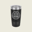 A black insulated travel tumbler with a clear lid, featuring a circular silver graphic of two horses and the word 'HYDRAS' on the front, set against a solid light beige background.