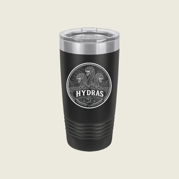 A black insulated travel tumbler with a clear lid, featuring a circular silver graphic of two horses and the word 'HYDRAS' on the front, set against a solid light beige background.