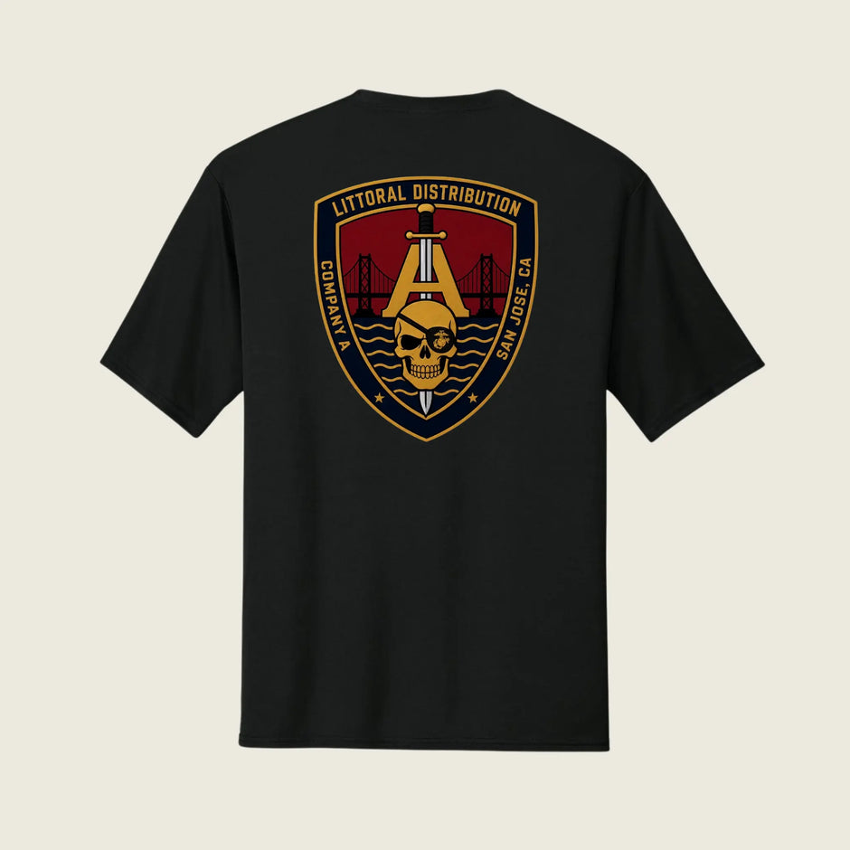 A black short-sleeve t-shirt shown from the back, featuring a large military-style crest graphic on the center back. The graphic includes a gold anchor, a skull, a red background, and the text 'LITTORAL DISTRIBUTION' and 'SAN JOSE, CA'