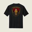 A black short-sleeve t-shirt shown from the back, featuring a large military-style crest graphic on the center back. The graphic includes a gold anchor, a skull, a red background, and the text 'LITTORAL DISTRIBUTION' and 'SAN JOSE, CA'
