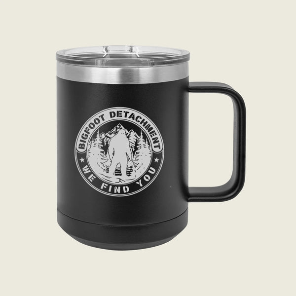 Black mug with 'Bigfoot Detachment' logo on a beige background