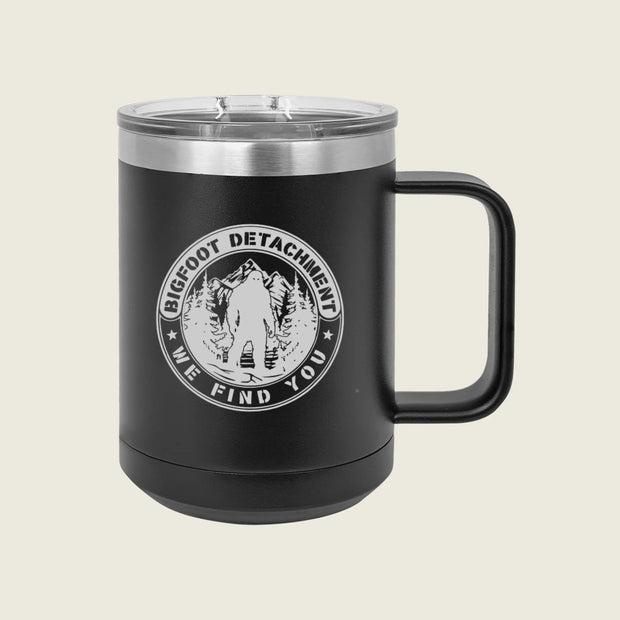Black mug with 'Bigfoot Detachment' logo on a beige background