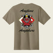 A taupe brown short-sleeve t-shirt shown from the back, featuring a graphic of a red demon skateboarder with flames and skulls, framed by the words 'Anytime Anywhere' in black script.